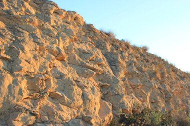 Güneşin günbatımında aydınlattığı bir kaya yamacının dokusu