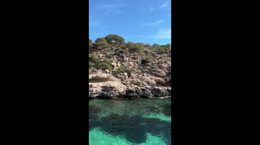 İspanya 'da güneşli bir günde, berrak suyu ve kayalık tepesi olan bir gölün parçası.