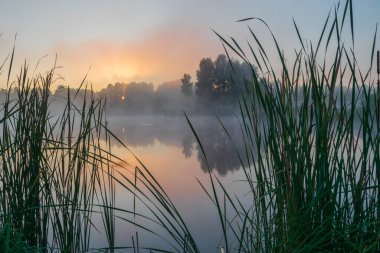 Sis ile birlikte gölde gün doğumu
