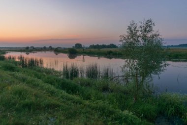 Yaz akşamları sakin nehrin üzerinde gün doğar..