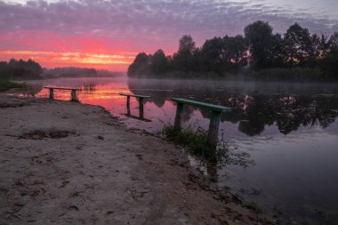 Sis ile gölün üzerinde gün doğumu