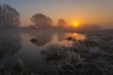 Bir nehrin sabah manzarası ve güzel bir gündoğumu olan bir nehir..
