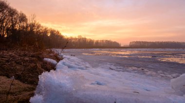 Gün batımında donmuş kış nehri