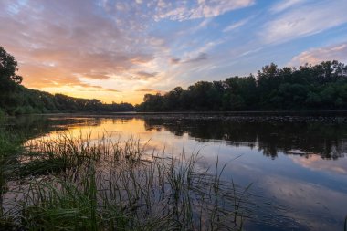 Sonbaharda yansımaları ve ağaçlarıyla gölde gün batımı