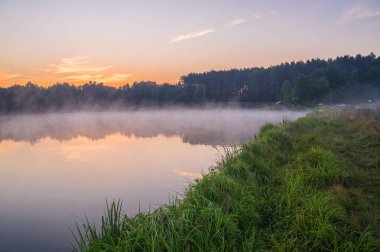 Güneşin doğuşu sisli nehirde.
