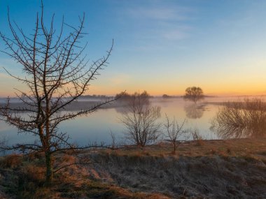 Sabahın köründe nehirde gün doğumunda. İlkbahar başı.