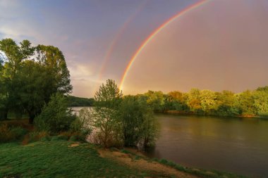 Sabah nehirde gökkuşağı. Nehrin gökkuşağı suya yansıyor..