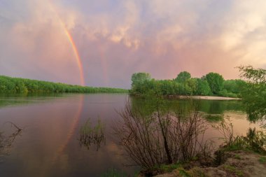 Gün batımında gökkuşağı ve nehir