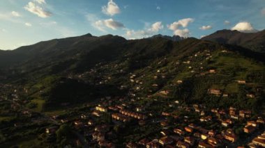 Geleneksel kırmızı çatıları yeşil dağlarla çevrili tarihi İtalyan köyünün yatay drone videosu, Toskana. Yüksek kalite 4k görüntü