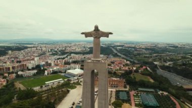 Kral İsa 'nın Lizbon' un üzerinde yükselen panoramik hava manzaralı sığınağı. İHA heykelin etrafında daireler çiziyor. Arka planda Almada şehir manzarası. Yüksek kalite 4k görüntü