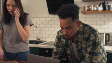 Sessiz bir sabahta mutfakta çok kültürlü bir çift. O telefonda konuşurken, o dizüstü bilgisayarına odaklanıyor. Onlar sakin bir rutini paylaşırken masada bir salata var. Yüksek kalite 4k görüntü