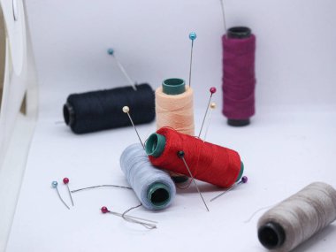 Metin için yeri olan gri arkaplanda iplikler dikiliyor.