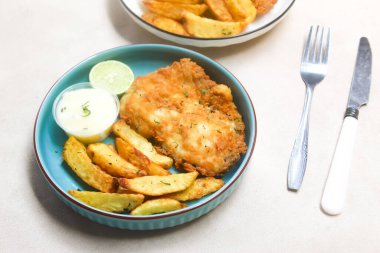 balık ve patates kızartması masada servis edilir.