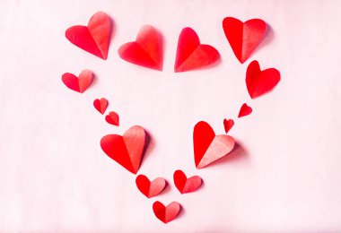 Pembe arka planda kırmızı kalpler sevgililer günü süsü