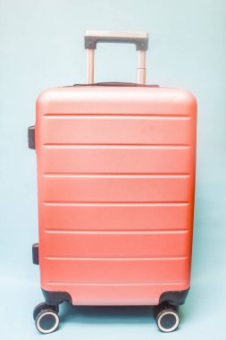 Mavi arka planda pembe bir bavul, seyahat için mükemmel.