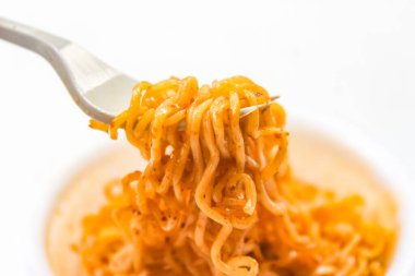 Çatal beyaz arka planda erişte topluyor.