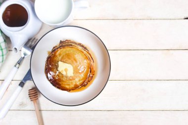 Kahvaltı menüsü olarak masaya bal ve tereyağlı bir tabak krep..