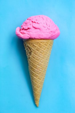 Mavi arka planda çilek aromalı dondurma külahı