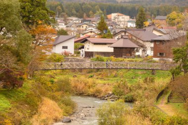 Japon Alpleri 'nin arka planda olduğu Hakuba Köyü' nün güzel manzarası ve sonbaharda içinden akan temiz bir dere, Oide Park, Nagano Bölgesi, Japonya manzarası 