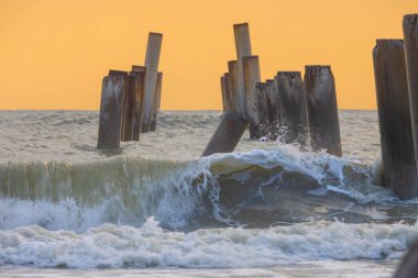  A beautiful sunrise at Sao Eang Beach (Old leaning cement pillars) Cha-Am beach is a famous about a lot of old leaning cement pillars of the pier located in Cha-Am beach Phetchaburi Thailand clipart