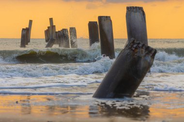  A beautiful sunrise at Sao Eang Beach (Old leaning cement pillars) Cha-Am beach is a famous about a lot of old leaning cement pillars of the pier located in Cha-Am beach Phetchaburi Thailand clipart