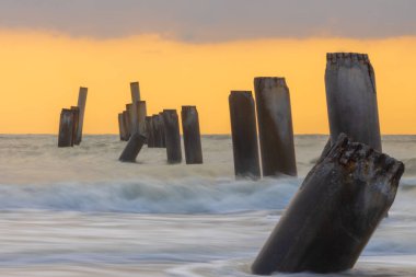  Sao Eang Sahili 'nde güzel bir gündoğumu Cha-Am plajı, Cha-Am plajındaki Phetchaburi Tayland sahilindeki iskelenin eski eğimli sütunlarıyla ünlüdür.