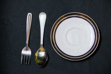 Siyah arkaplanda gümüş çatal bıçak takımı