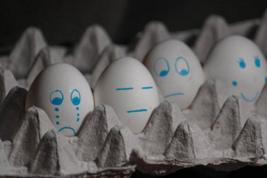 Siyah arka planda üzgün beyaz yumurtalar