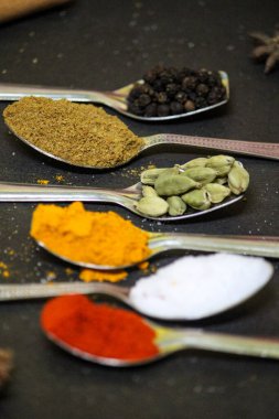 Masadaki kaşıklardaki baharatlar ve otlar.