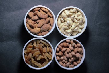 Siyah arka planda farklı kurutulmuş meyve ve fındıklar.