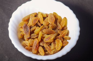 Beyaz masada bir kase kuru üzüm, üst manzara.