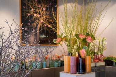 Decorative glass vases with flowers. Flamingo flowers (Anthurium) in the foreground. clipart