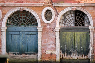 Arka planda iki eski kapı var. Venedik 'in renkleri. Terracotta, deniz mavisi ve antika yeşili. Renklerin uyumlu kombinasyonu.