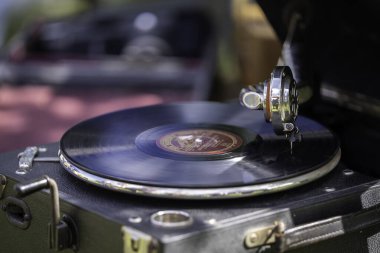 Bit pazarında eski moda gramofonda çalan eski bir retro plak. Taşınabilir gramofon işi. Eski, pejmürde bir plak çalar, fonograf, potefon. Nostalji antika döner tablosu.