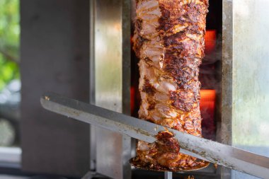 Şef geleneksel Türk donör kebap eti hazırlıyor ve yapıyor. Ev restoranında geleneksel Türk yemeği Doner Kebabı veya Yunan jiroskopu yapmak için ızgara et kullanılır. Dilimleme Doner Kebabı.