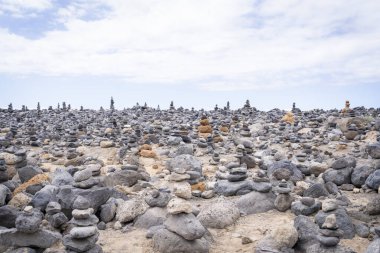 Deniz kenarındaki Cairns, Costa Adeje, Tenerife. Costa Adeje sahilinde dengelenmiş taş yığınları. Taş dengesi sanatı ya da kumsalda taş yığınları..