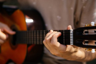 Genç adamlar dışarıda akustik gitar çalıyorlar. Yüksek kalite fotoğraf