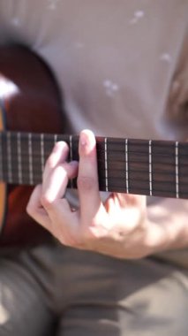 Genç adam dışarıda akustik gitar çalıyor. Yüksek kalite 4k görüntü