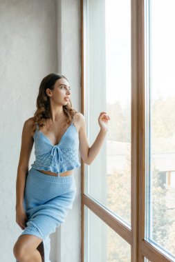 Beyaz odada mavi elbiseli güzel, genç bir manken. Yüksek kalite fotoğraf