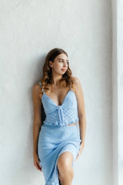 Beyaz odada mavi elbiseli güzel, genç bir manken. Yüksek kalite fotoğraf