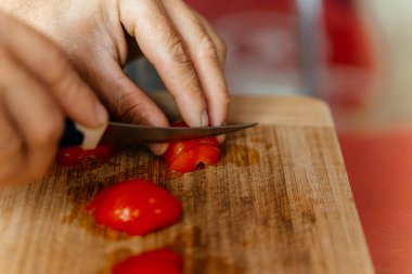 Bir şef domatesi kesme tahtasının üzerinde bıçakla kesiyor. Yüksek kalite fotoğraf