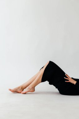 Siyah kurdeleli, kendine güvenen genç bir kadın zarif beyaz bir arka plana karşı zarif bir şekilde poz verir. Zarafeti ve tarzı somutlaştırır. Yüksek kalite fotoğraf