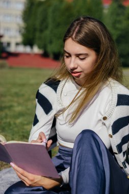 Öğrenci kız yazın dışarıda çalışıyor. Holliday 'de yeşil çimlerin üzerinde dizüstü bilgisayar kullanıyor ve not alıyor.