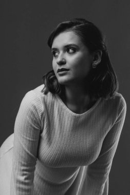 Şık ve zarif bir genç kadın stüdyo ortamında zarifçe poz veriyor. Yüksek kalite fotoğraf