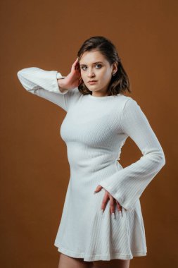 Şık ve zarif bir genç kadın stüdyo ortamında zarifçe poz veriyor. Yüksek kalite fotoğraf