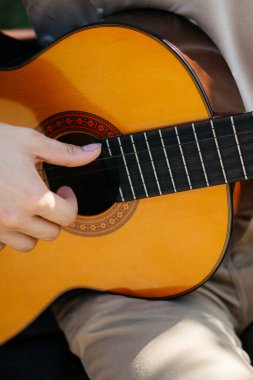 Genç adamlar dışarıda akustik gitar çalıyorlar. Yüksek kalite fotoğraf