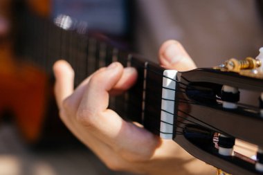 Genç adamlar dışarıda akustik gitar çalıyorlar. Yüksek kalite fotoğraf