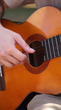 Genç adam dışarıda akustik gitar çalıyor. Yüksek kalite 4k görüntü