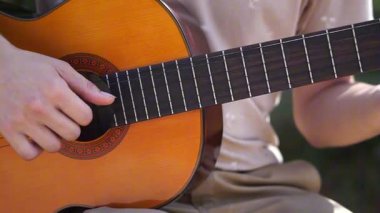 Genç adam dışarıda akustik gitar çalıyor. Yüksek kalite 4k görüntü