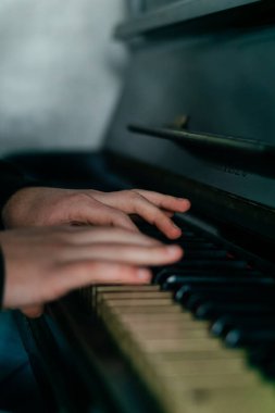 Eller zarif bir şekilde piyano çalar, müziğin, yaratıcılığın ve sanatsal ifadenin özünü yakın çekimde yakalar. Yüksek kalite fotoğraf